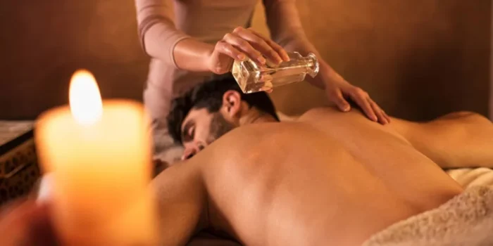 Masseuse Pouring Oil On The Mans Back